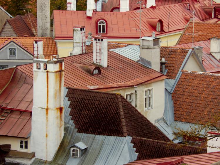 Chimneys poking out from a mish-mash of roofs in various shapes and shades of red