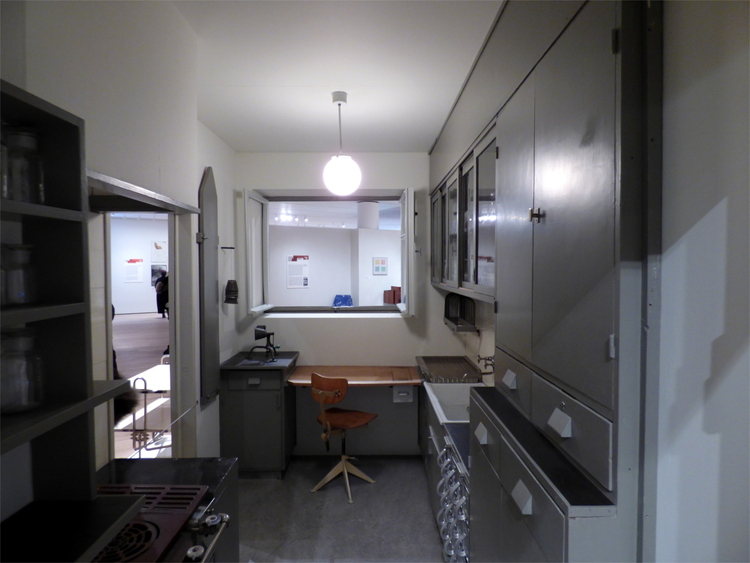 A small, cleanly-designed kitchen interior with light grey furniture