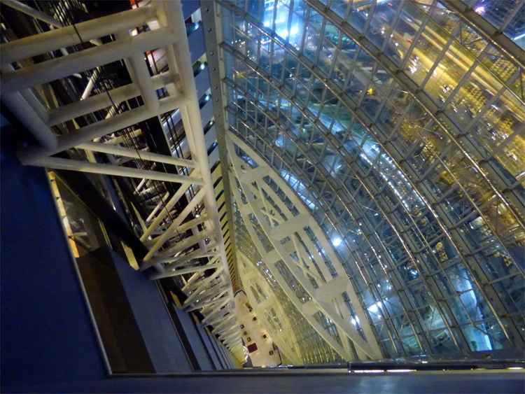 A view down the interior of a skyscraper showing the steel beam and glass construction