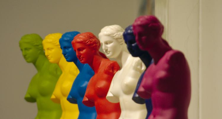 A row of plastic replicas of antique Greek statues in different colours