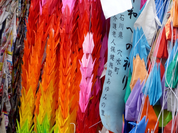 Strings of hundreds of origami cranes in various colours