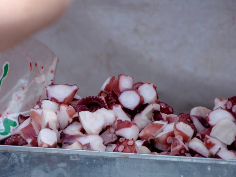 A tray with pieces of octopus meat with suction cups still visible