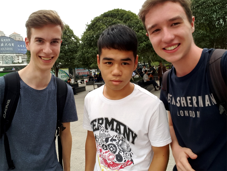 Nils and Jan posing for a picture with a slightly confused looking young Chinese man wearing a T-Shirt with 'Germany' written across the chest