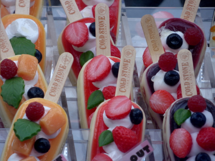 A display of plastic ice pops with pieces of berries and mango on top