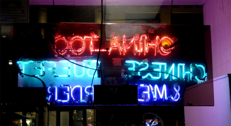 A red, green and blue neon sign photographed from behind