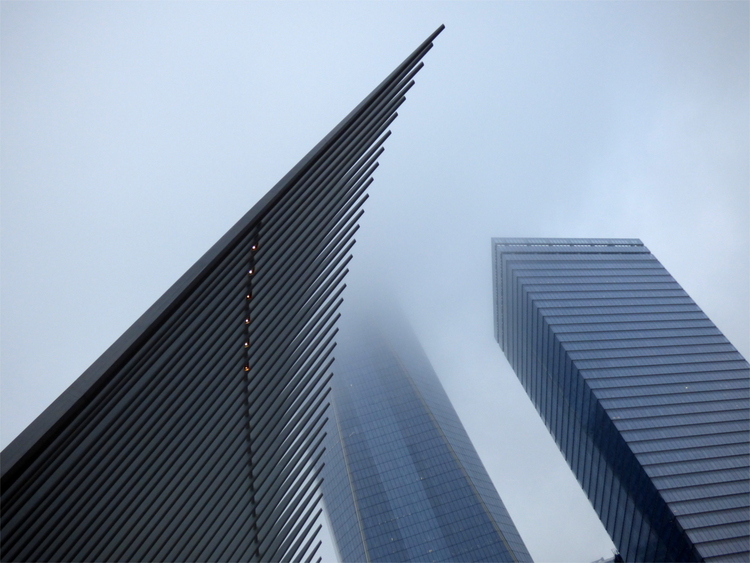 Parts of an extravagant modern building with heavy fog and two glass skyscrapers in the background