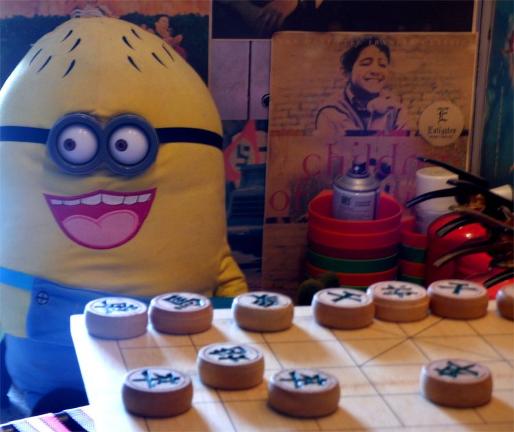 A Chinese chess set in front of a large Minion plush toy