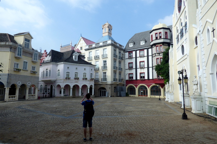 Jan standing on a miniature replica of a Belgian town square with pastel-coloured European-style houses