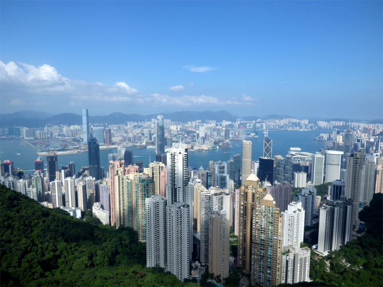 A look at Hong Kong from a mountain showing countless tall, skinny buildings and a river in the distance
